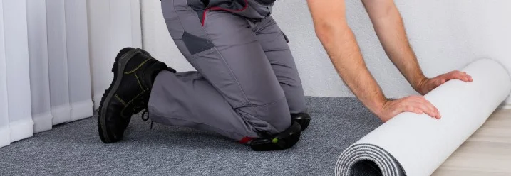 Person verlegt Teppichboden